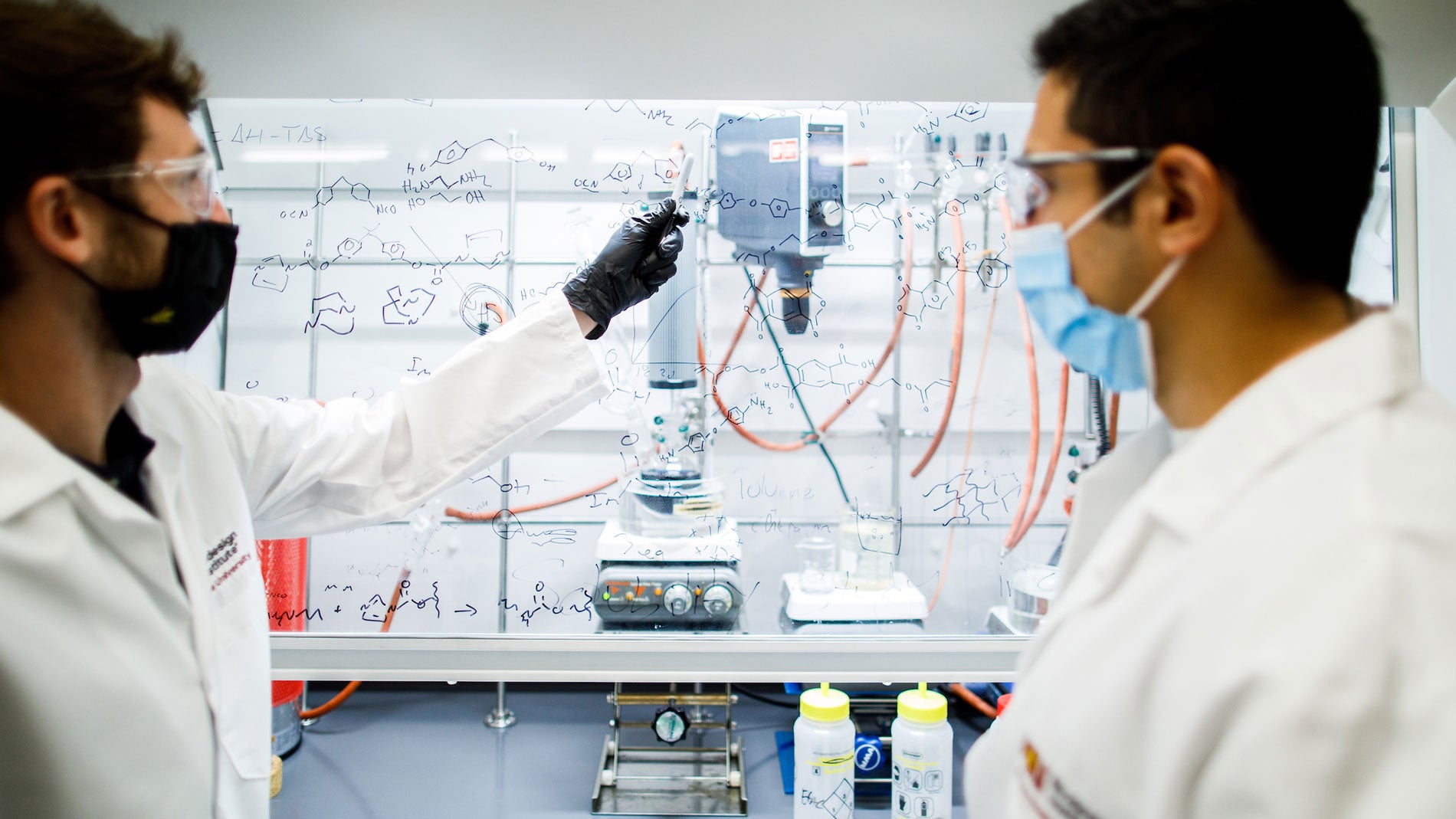 Graduate researchers Ren Bean and Jose Sintas discuss monomer chemical structures in the ASU Biodesign Center for Sustainable Macromolecular Materials and Manufacturing.