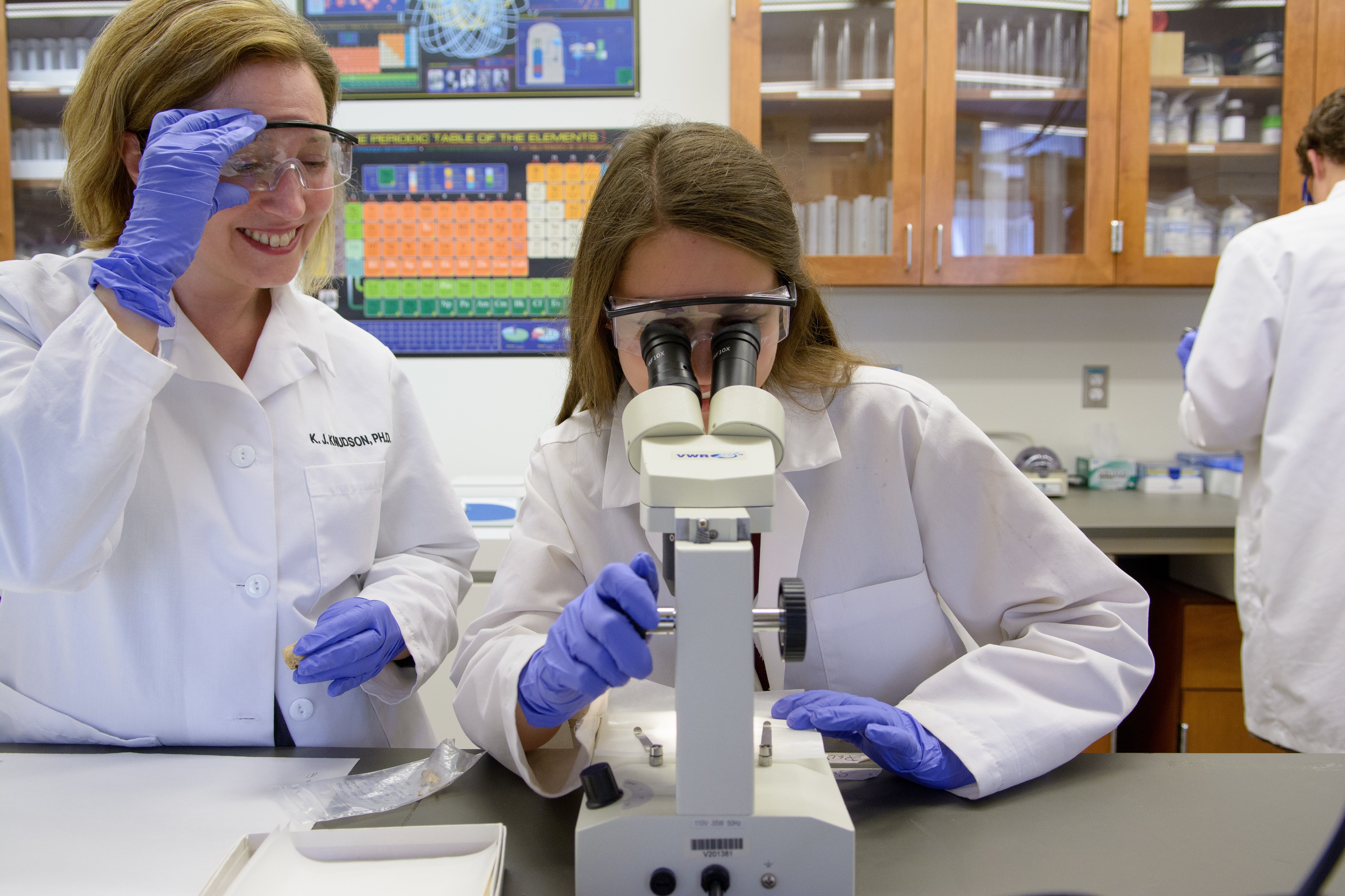 photo of Knudson and student looking at microscope