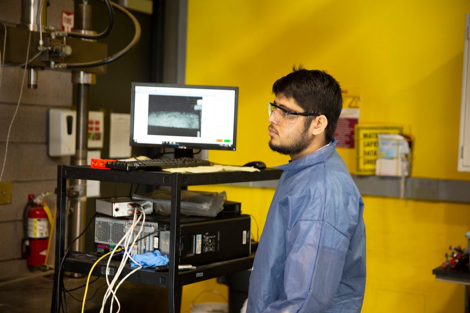 Ashutosh Maurya, a doctoral student at ASU, wears protective goggles and a jumpsuit while using imaging technology in a lab.