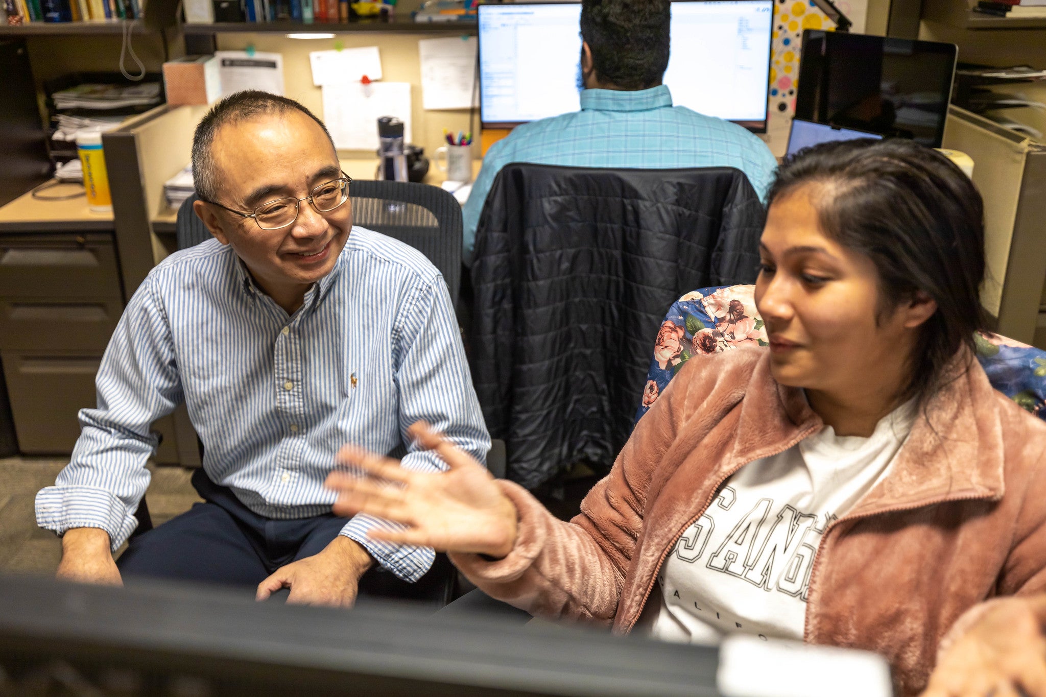 Professor interacting with student in computer lab