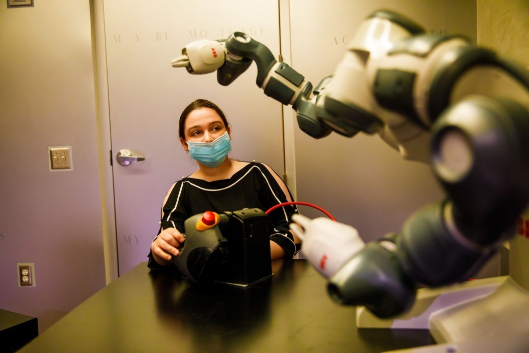 A researcher interacts with a robot