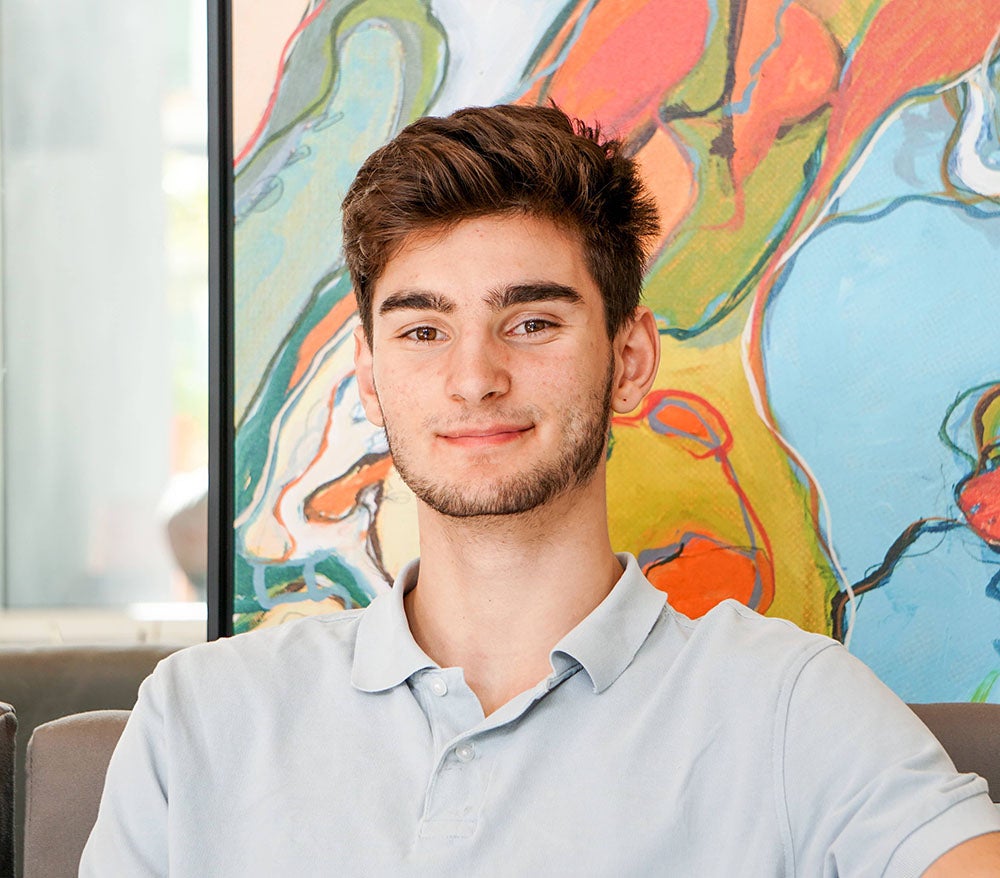 Young man with painting in the background