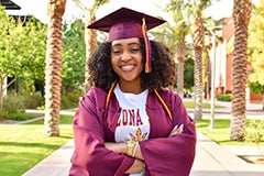 woman in cap and gown posing on Palm Walk