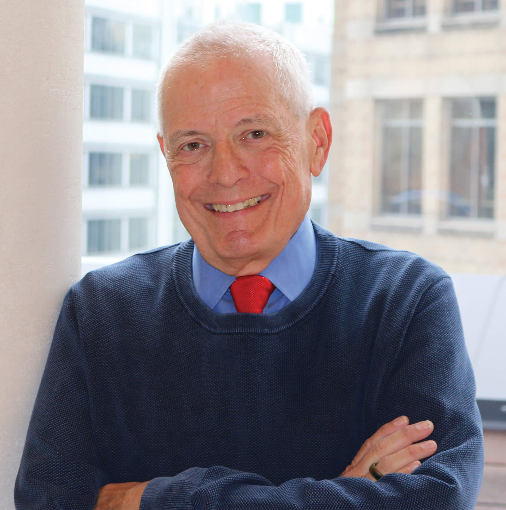 Man in blue sweater with arms crossed