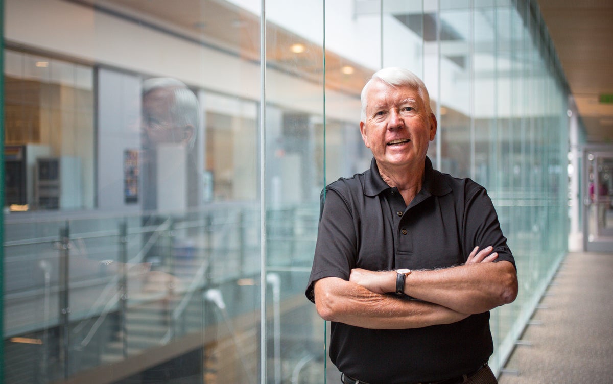 Guy standing next to a glass wall.