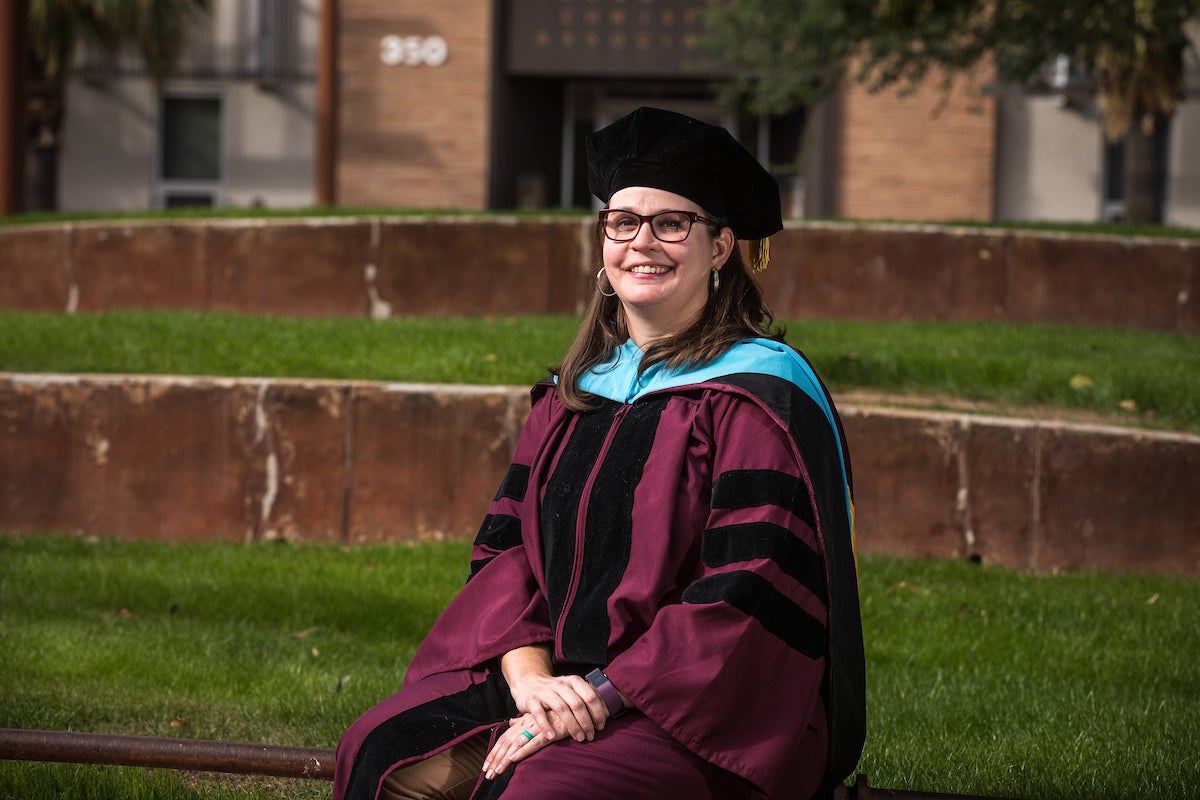 Woman in a robe sitting on a concrete bench