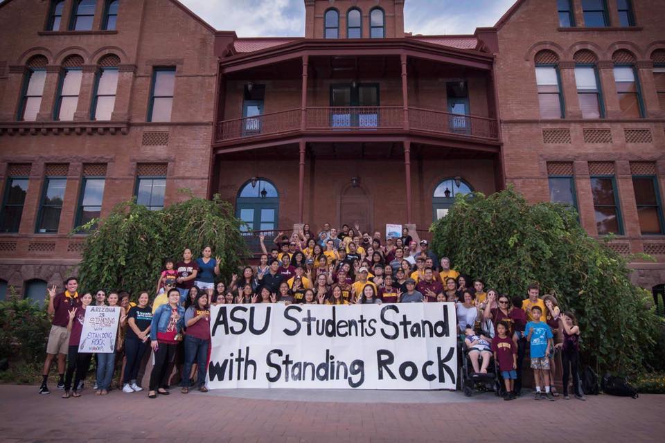 Students stand in front of building 