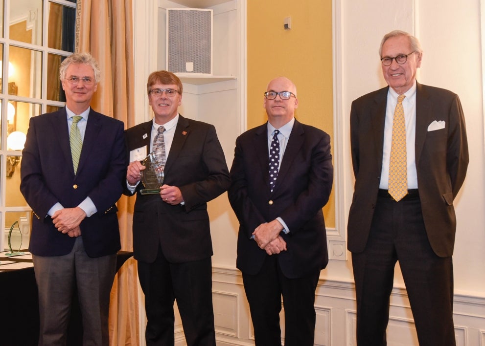 four men posing for award photo