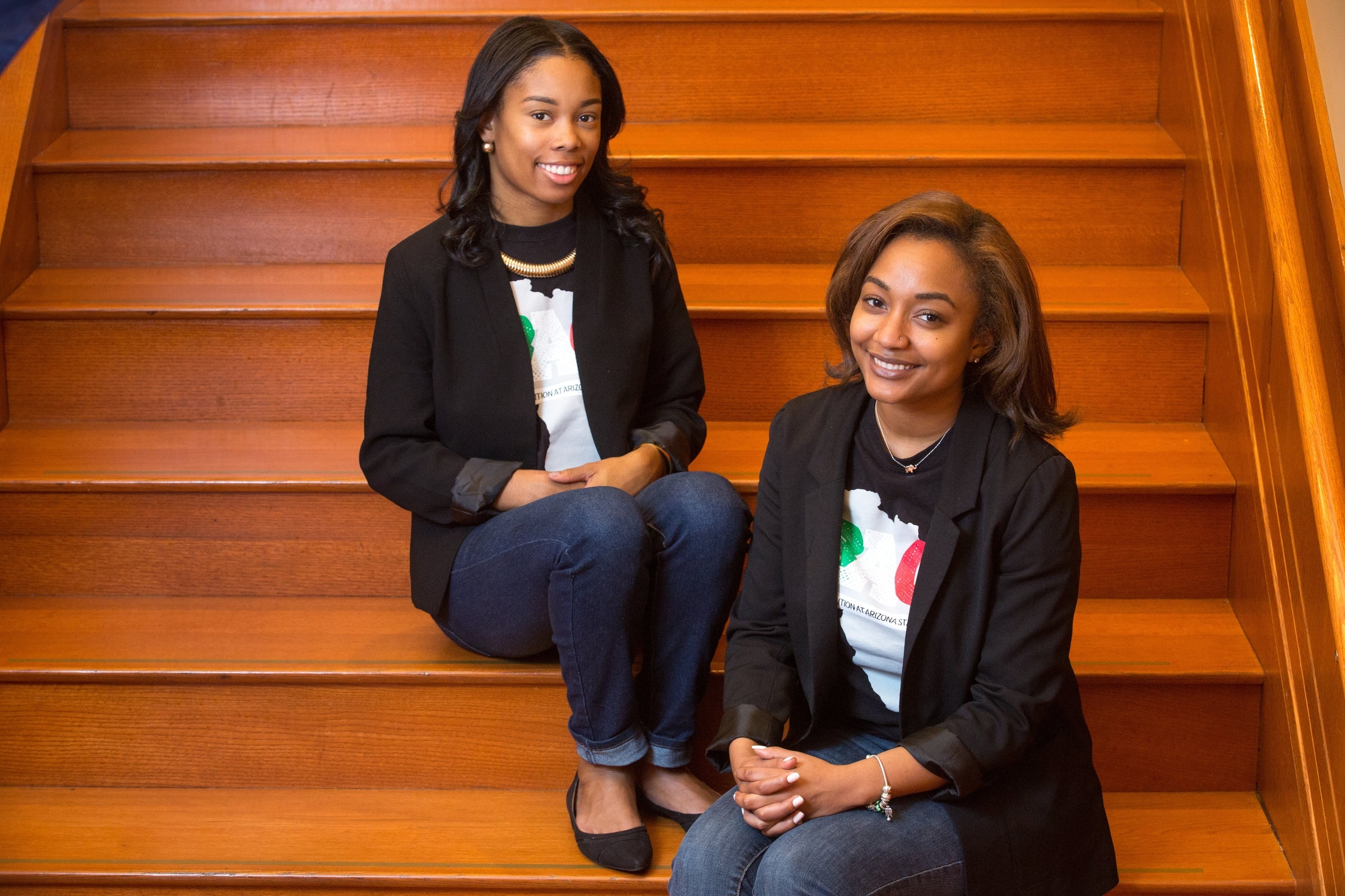 portrait of two women sitting on stairs