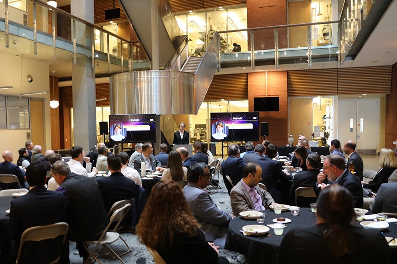 Barbara Barrett delivers an address from a podium while participants in the Arizona Space Summit enjoy lunch.