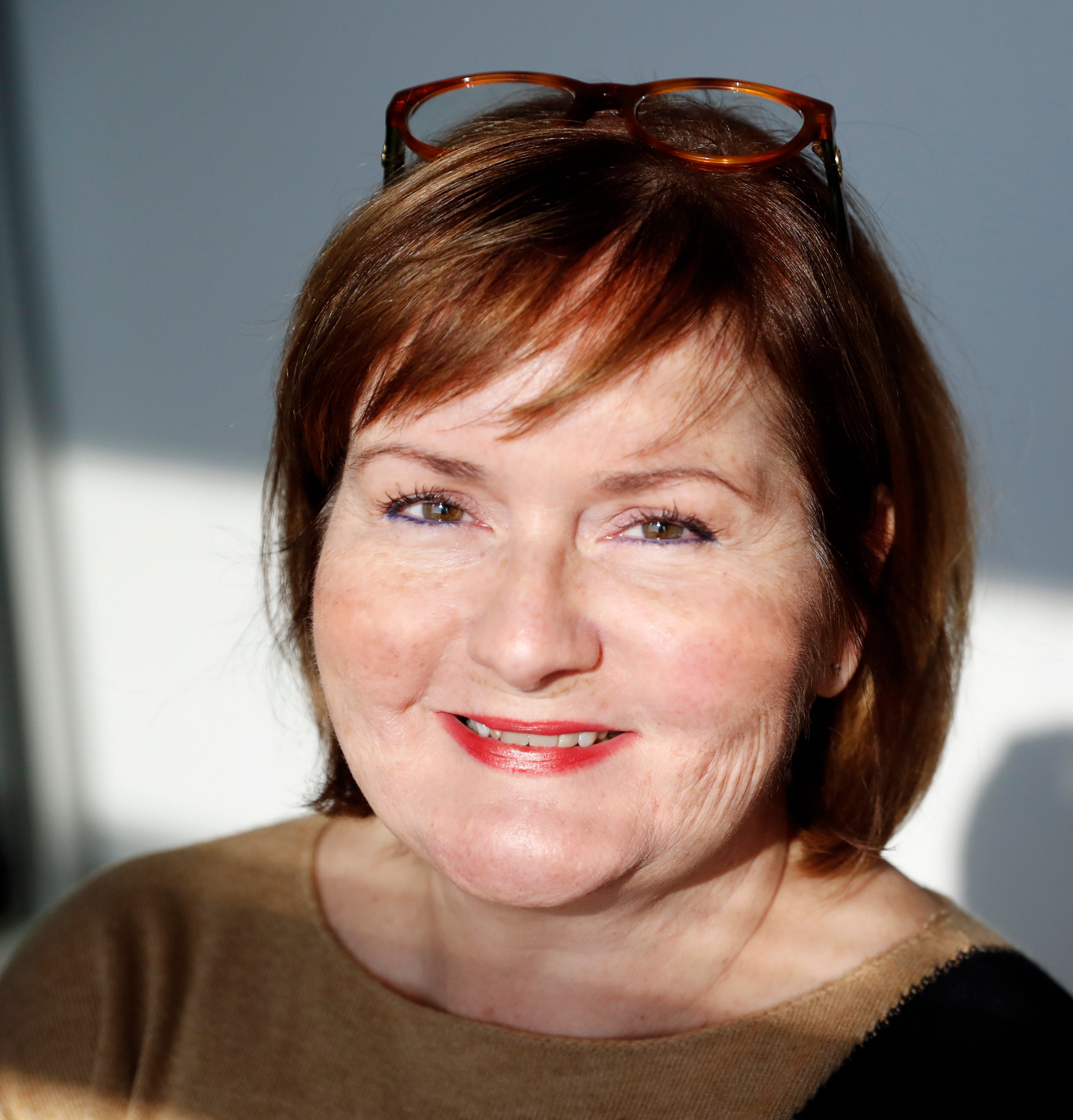 Woman in red hair with glasses on her head