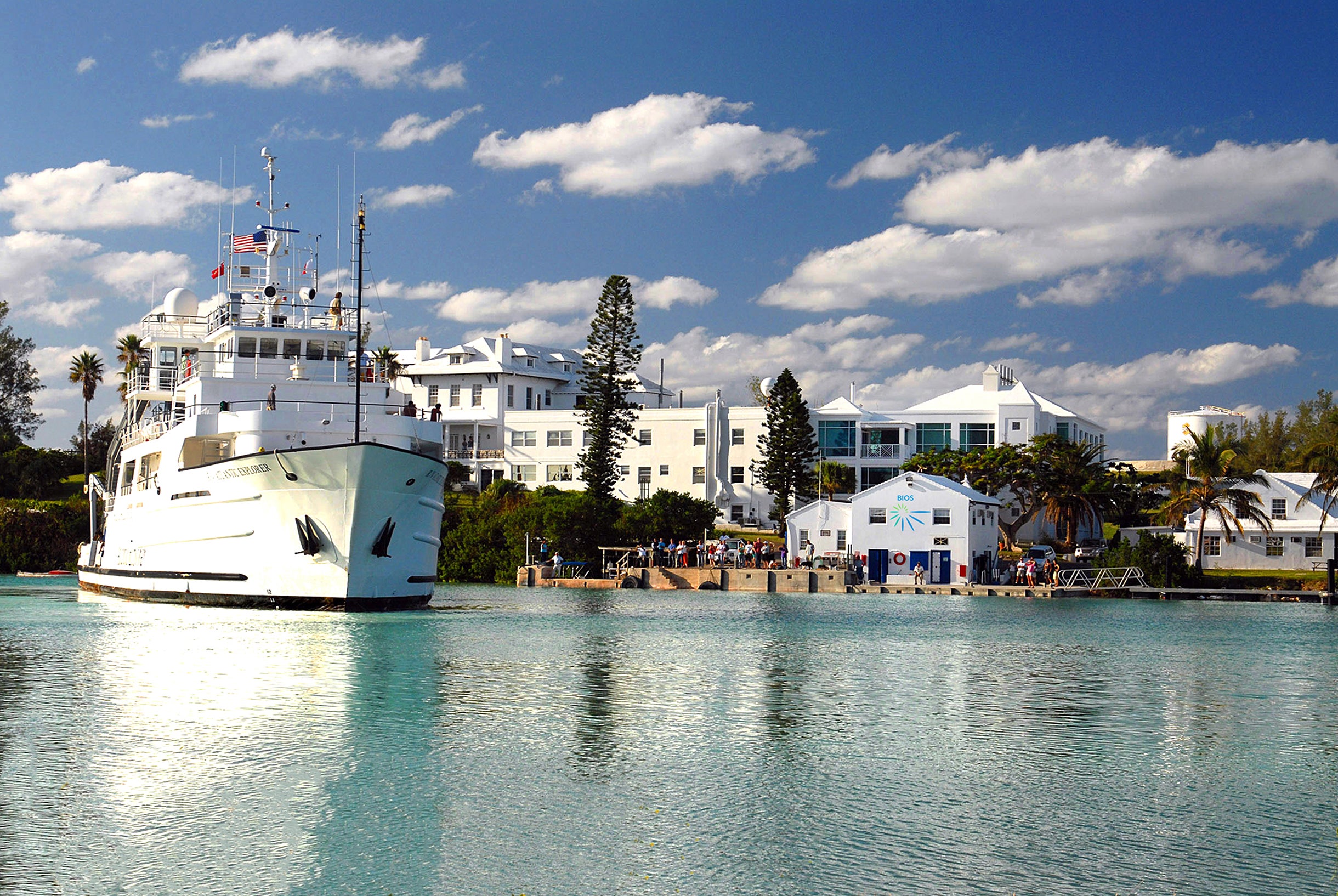 A medium-size ships is seen in front of a campus of white buildings in the Bahamas