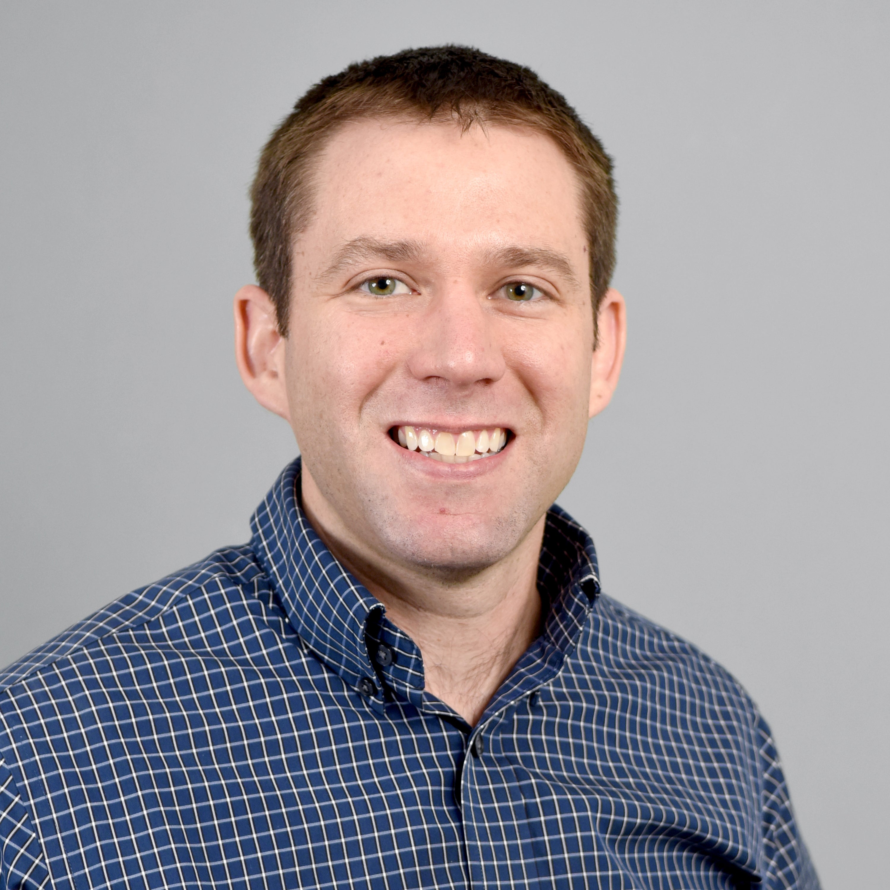 Man in blue and white shirt smiling