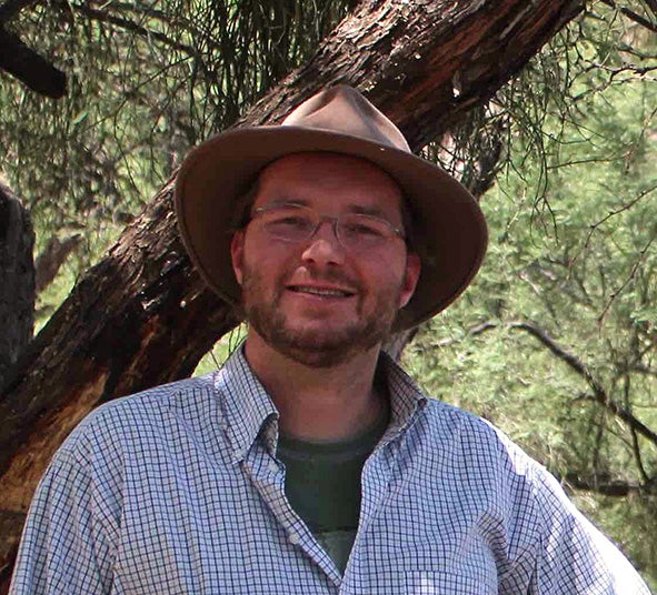 man's portrait outside in front of tree