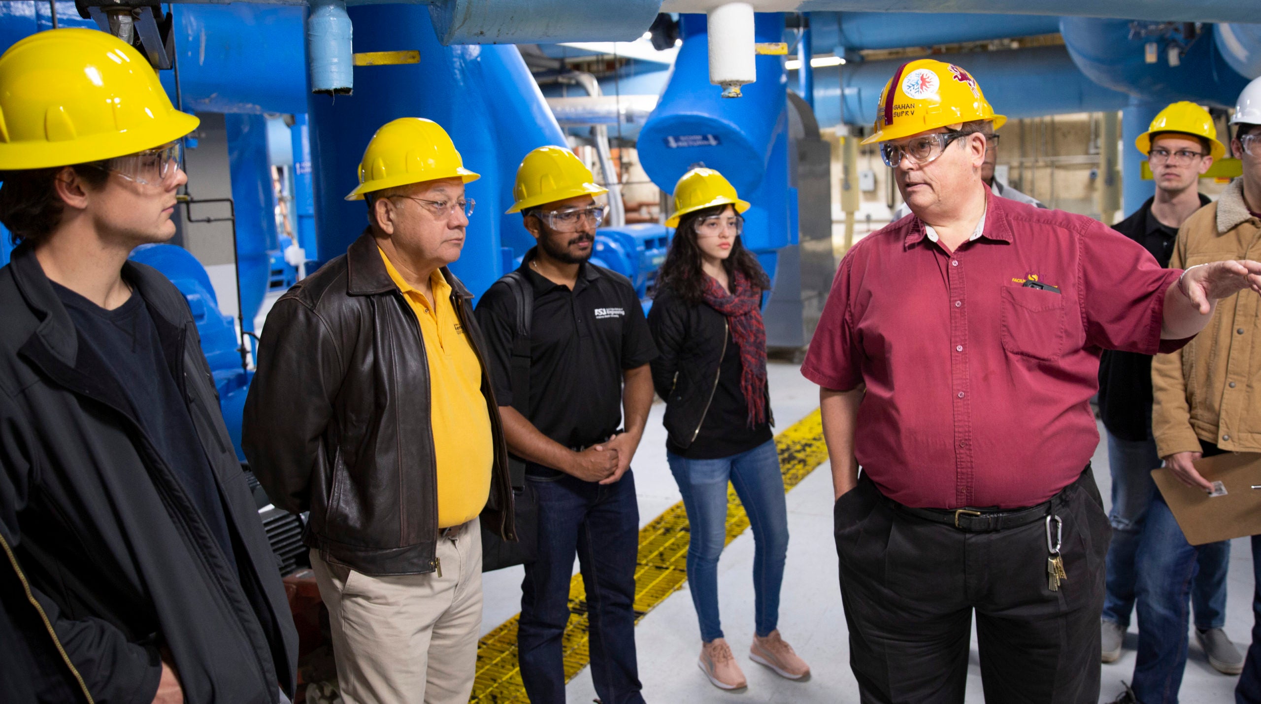 group of people talking in mechanical plant