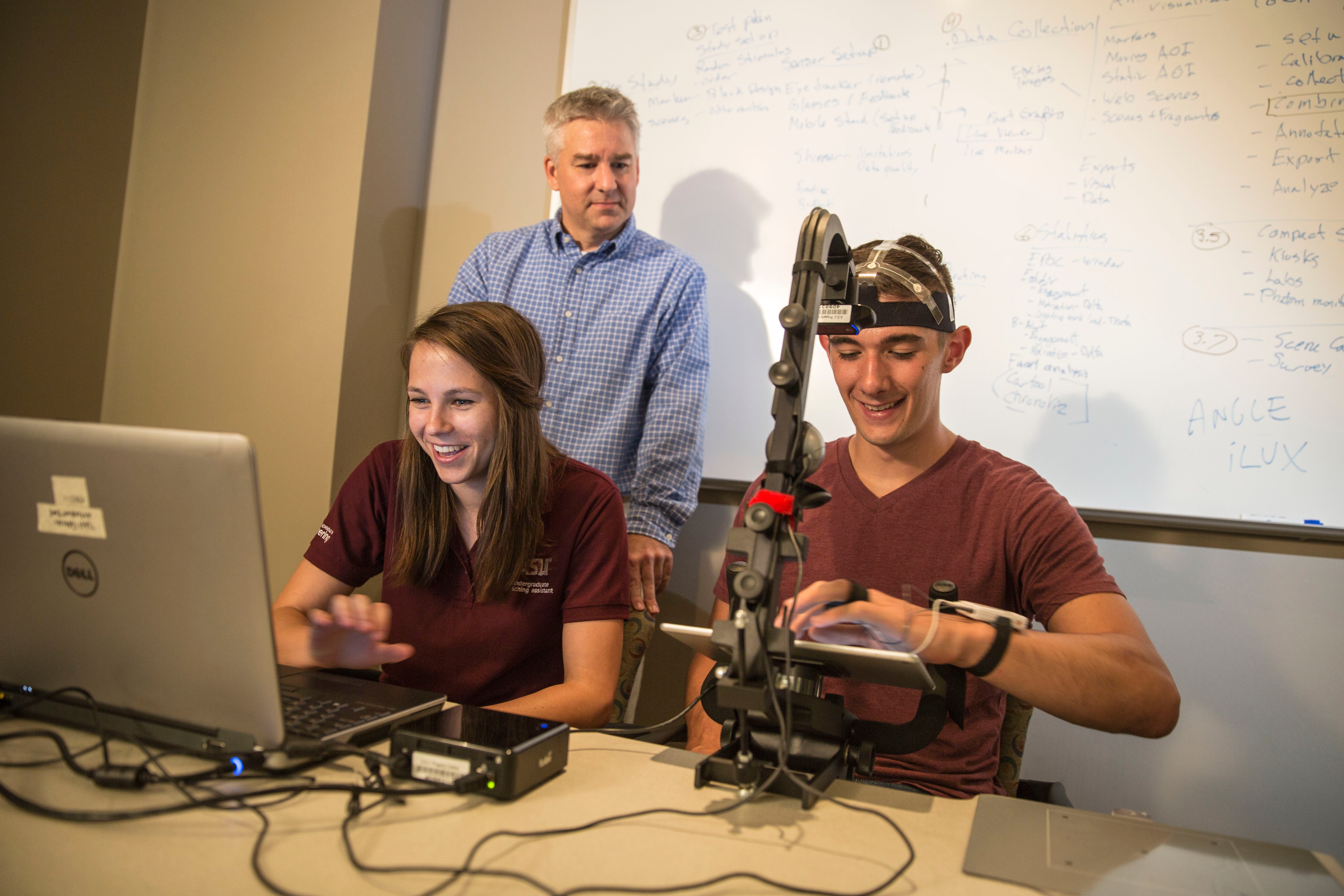 two students and professor working in lab