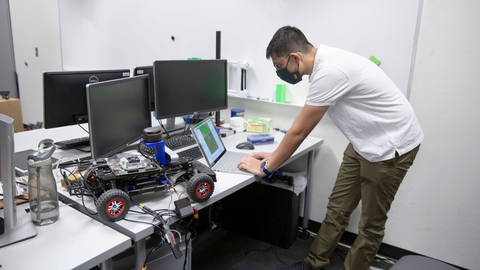 Parth Khopkar works with small autonomous vehicles in the lab