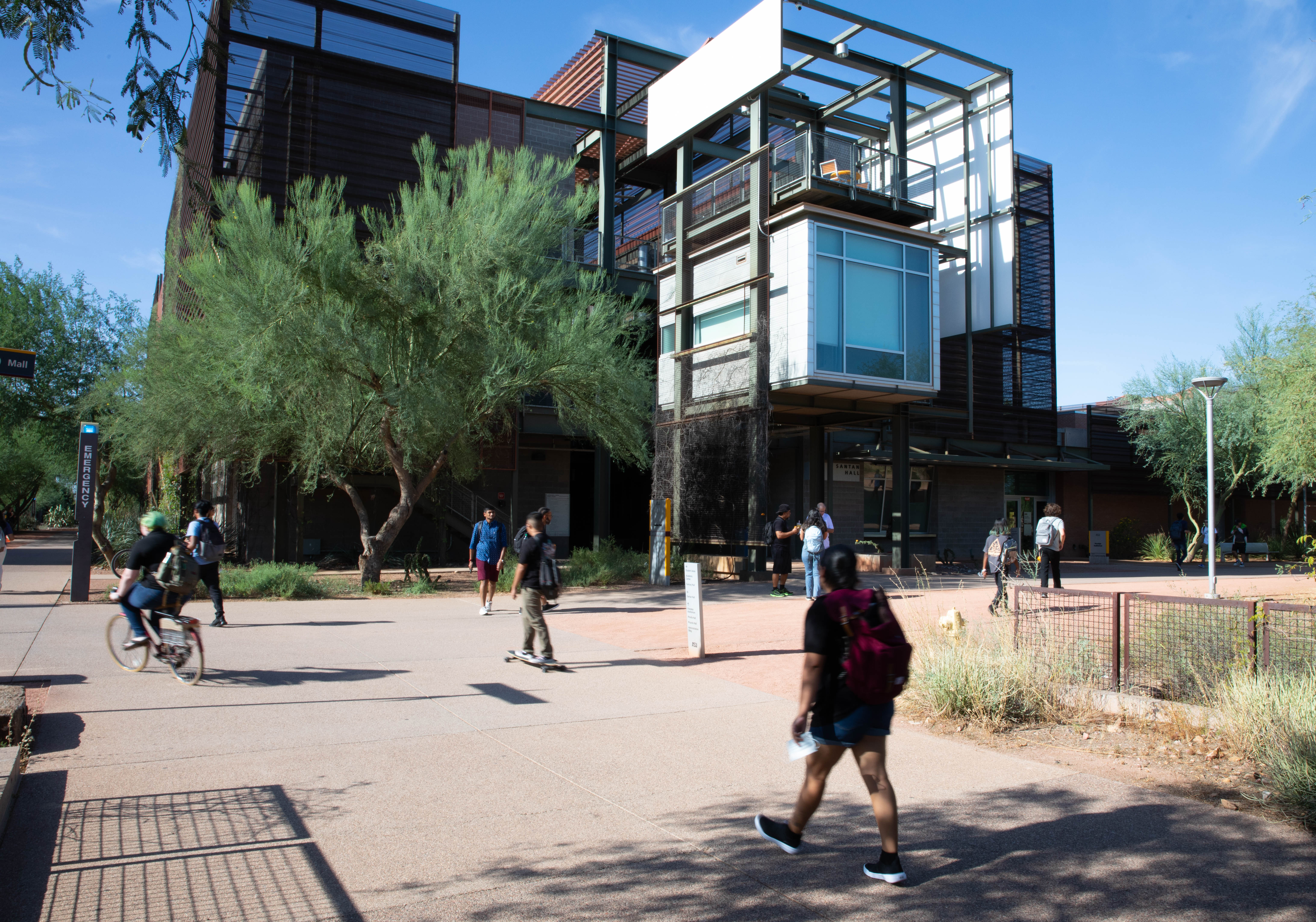 Students walk and bike down a mall on the Polytechnic campus