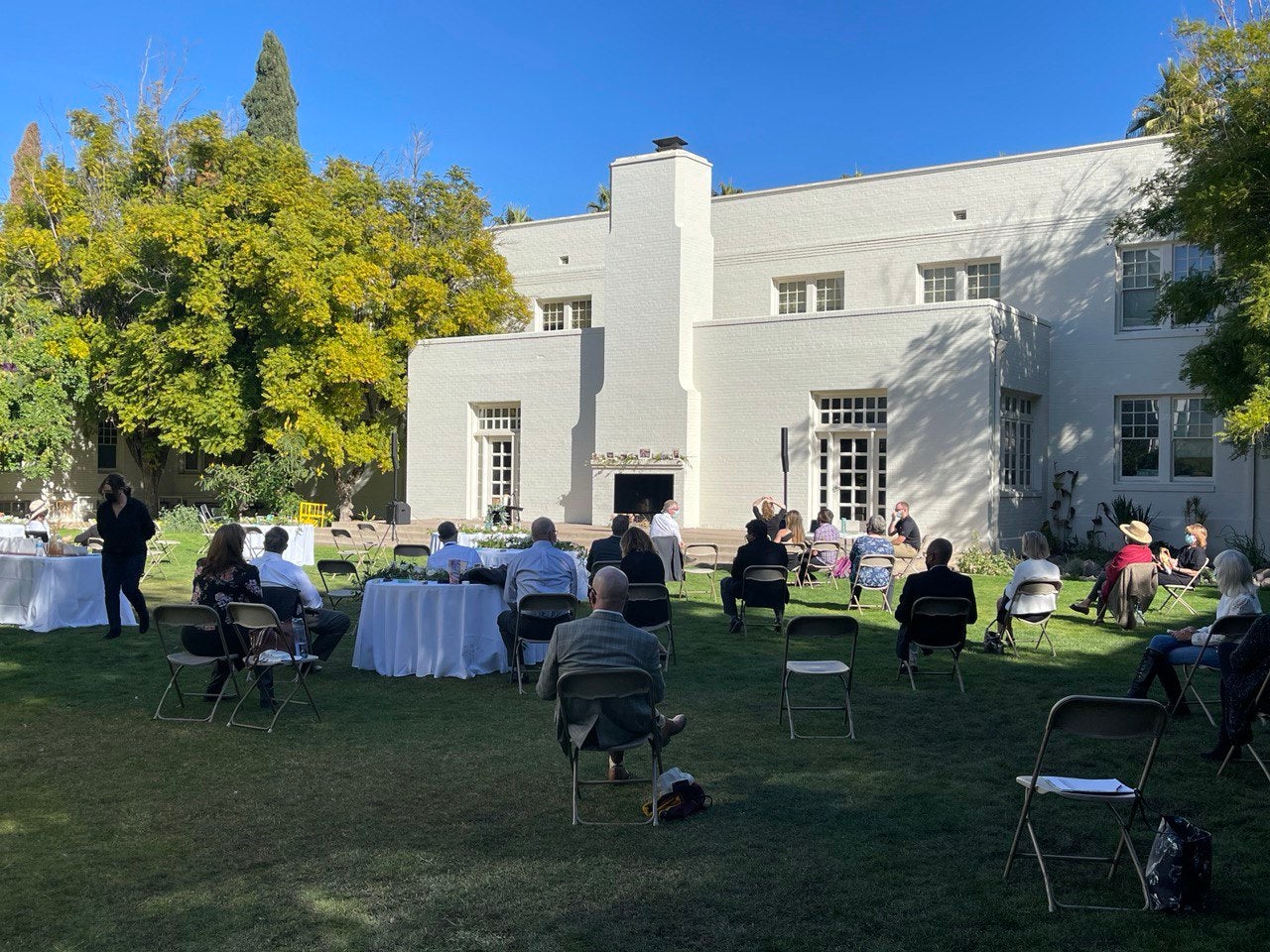 People gather in a grassy courtyard for a memorial service