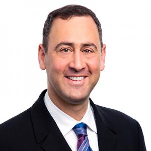 Man with brown hair and suit and tie