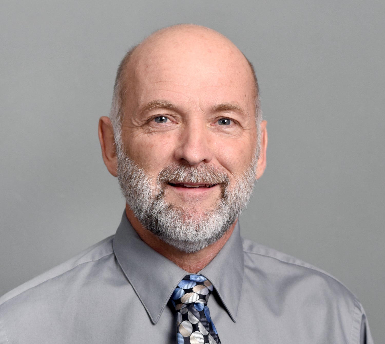 Man in grey shirt smiling