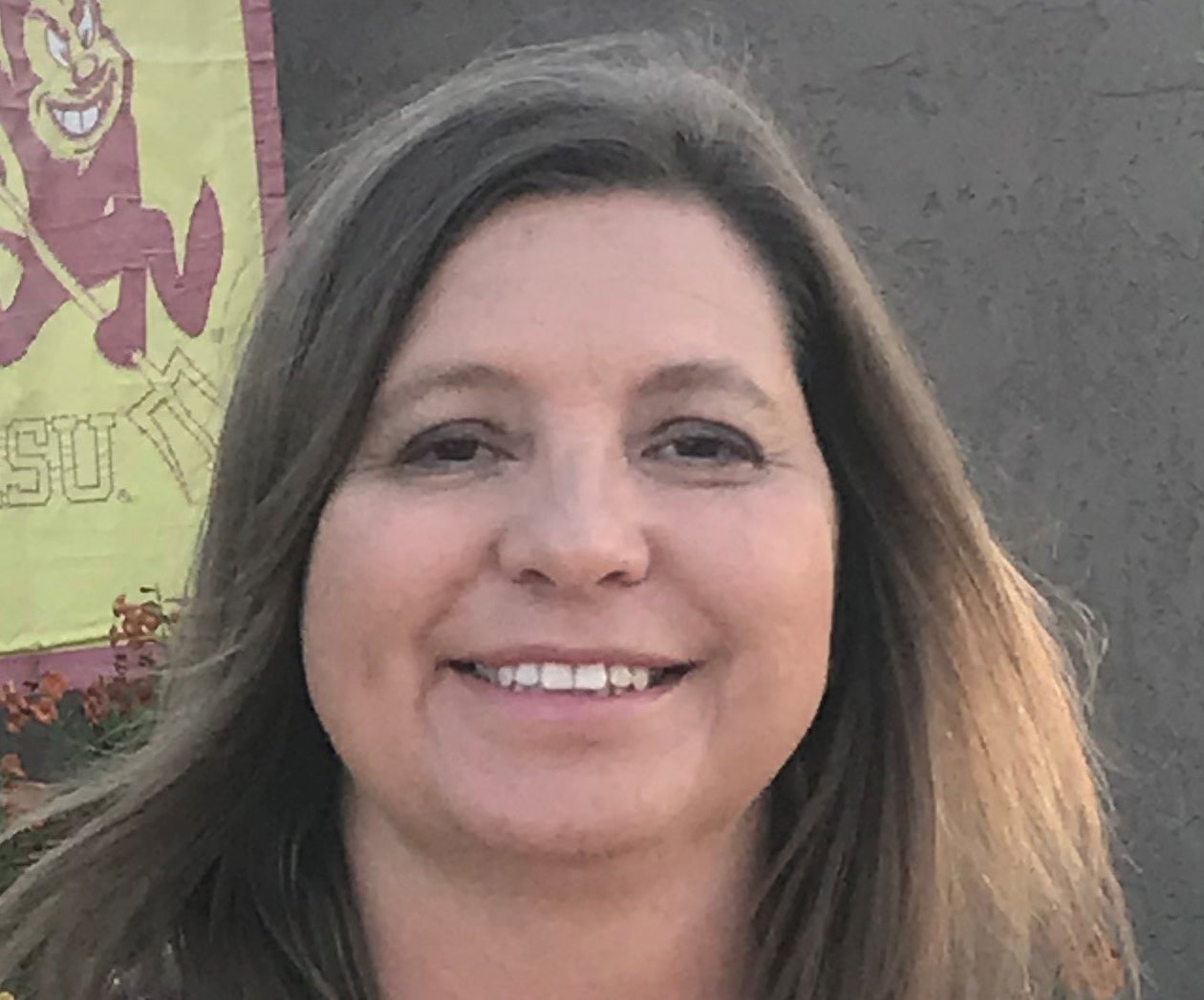 Woman with long brown hair and smiling