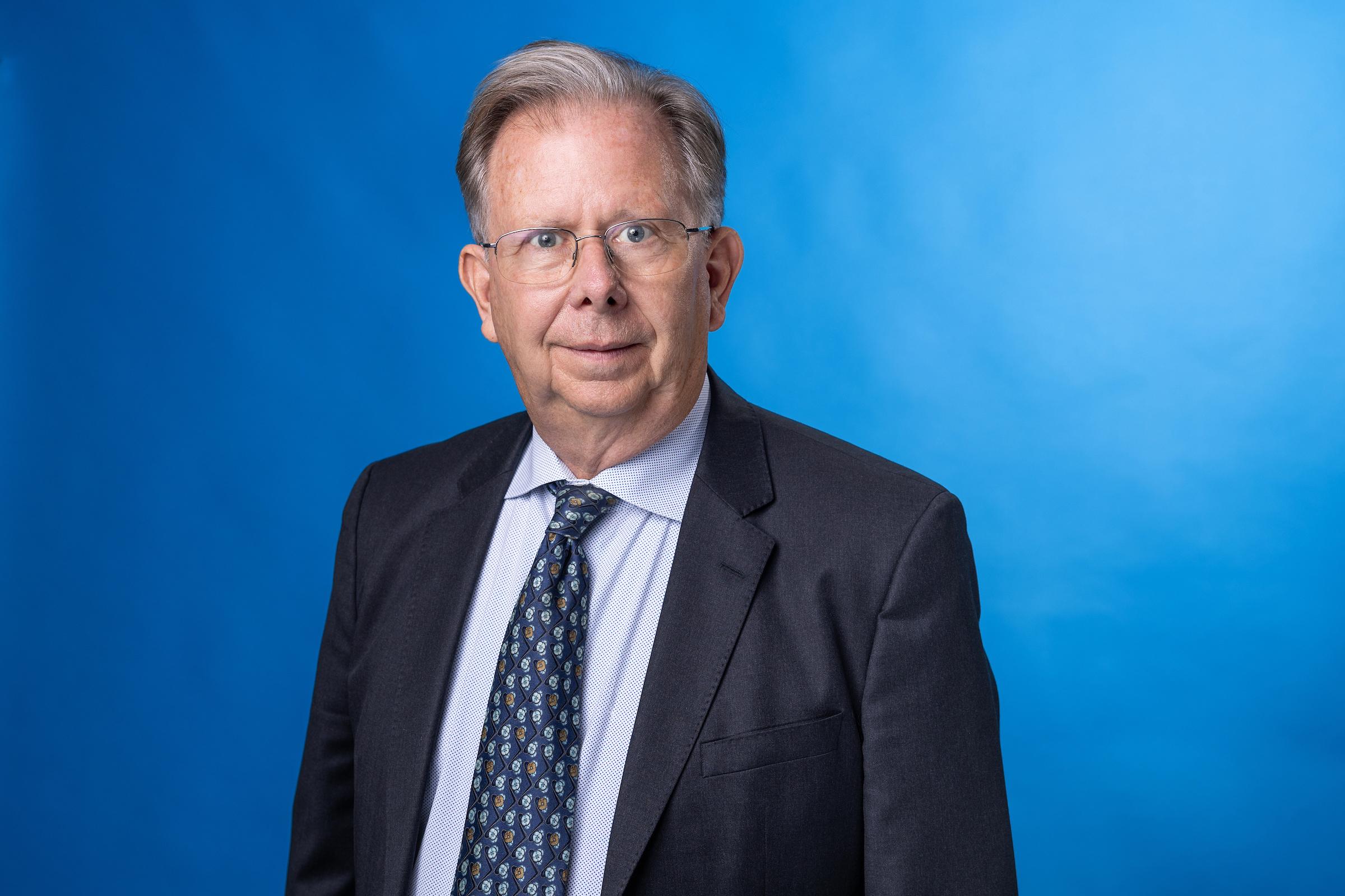 Man in black jacket and shirt smiling