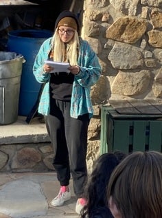 Student reading at front of class.