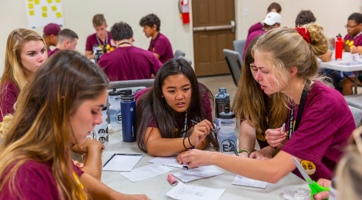 students sitting around table talking and working