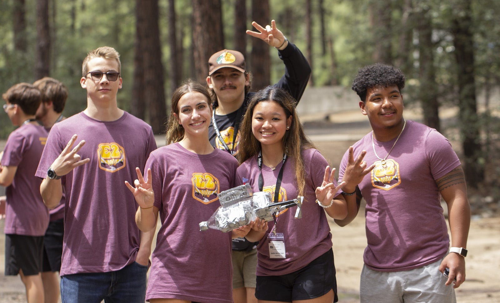 ASU students make a pitchfork sign with their hands.