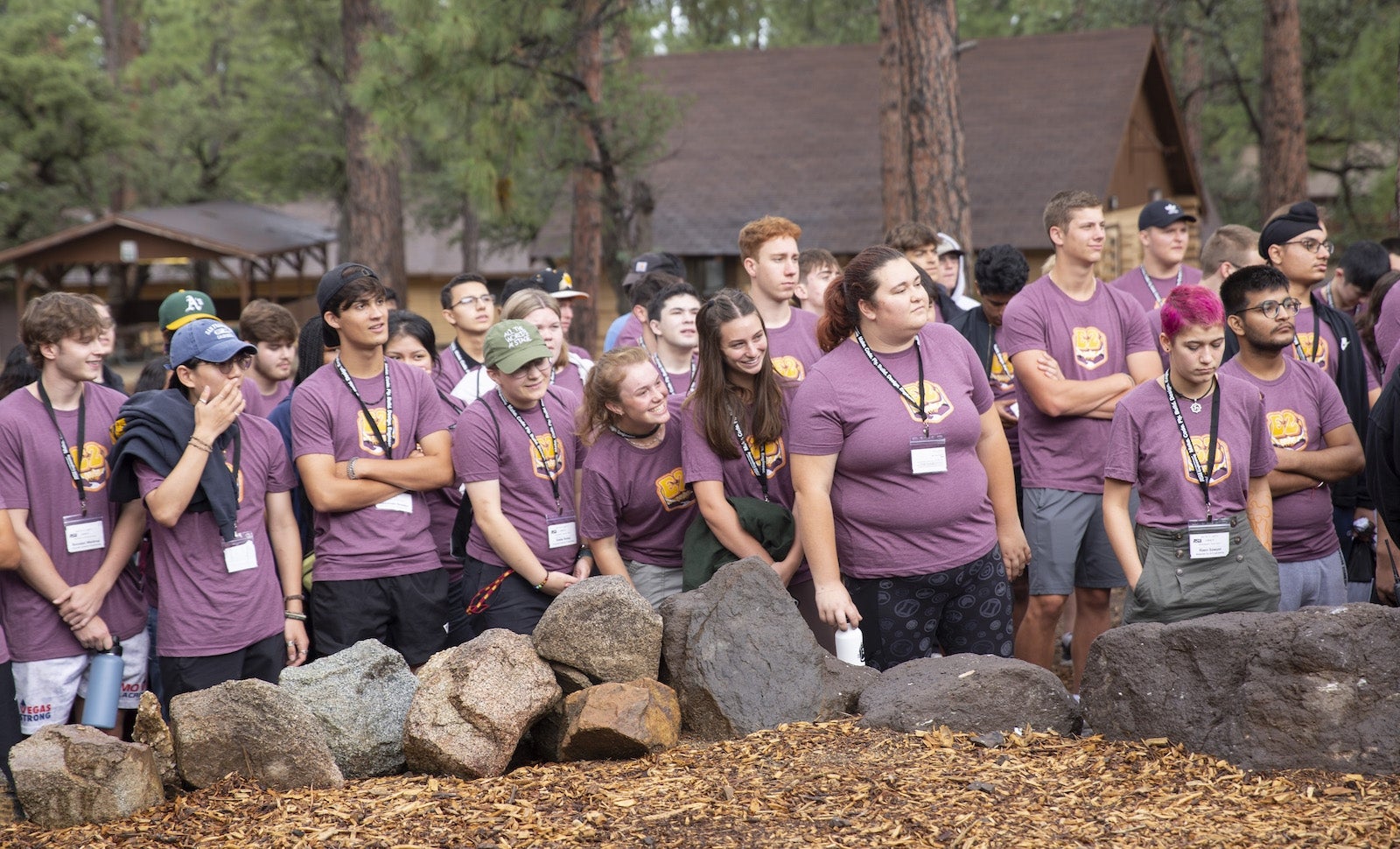 Crowd of ASU students standing in a wooded area.