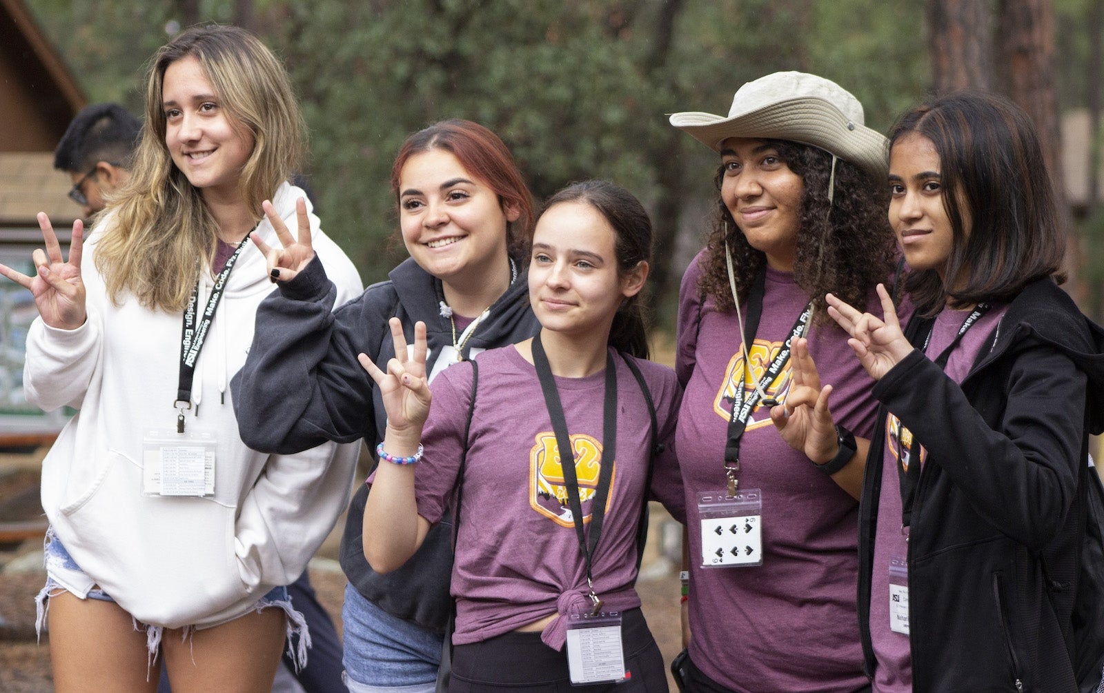 ASU students make a pitchfork sign with their hands.