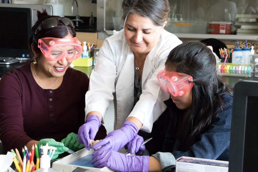 Emel Topal working with Girl Scout and parent in ASU Polytechnic lab