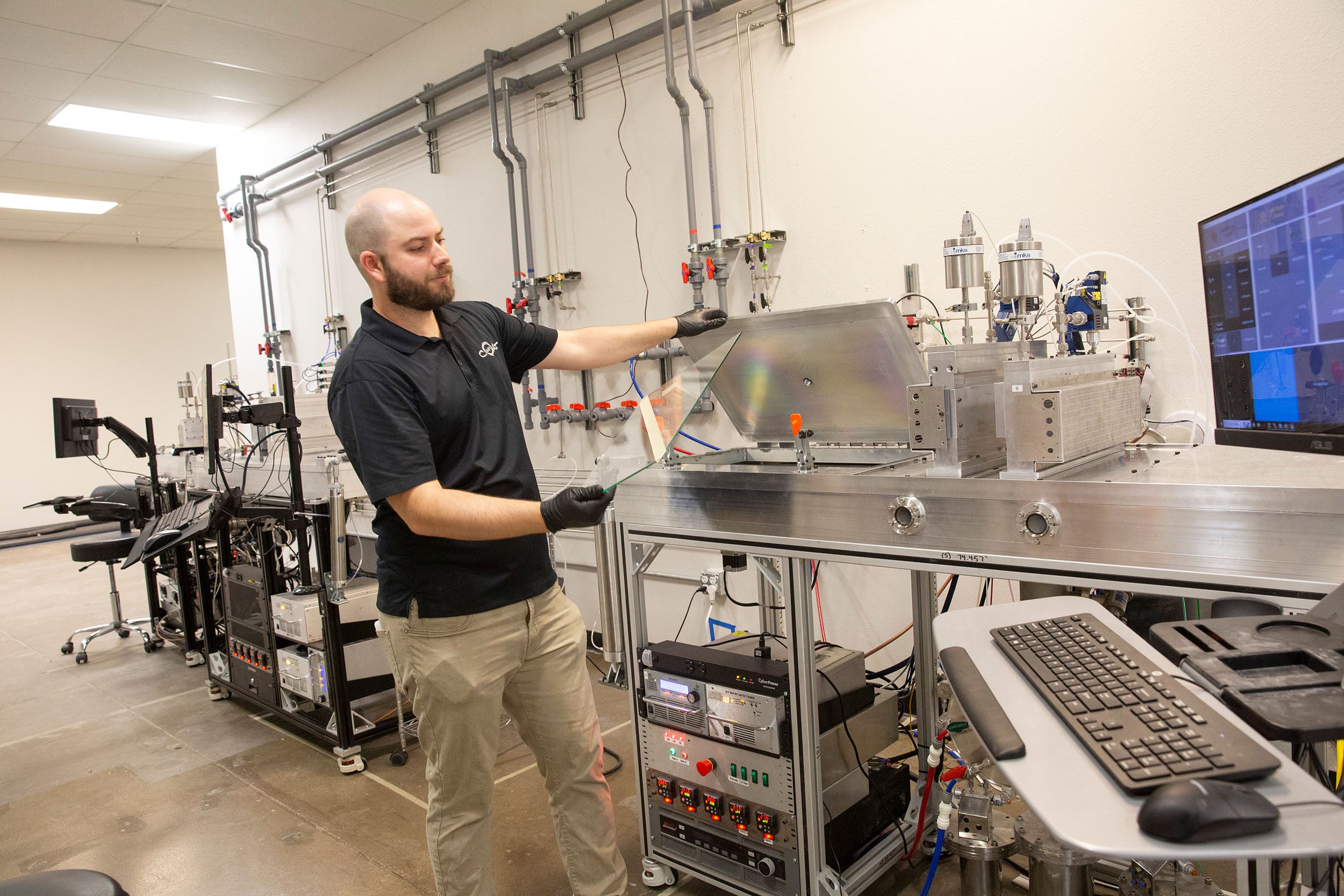 Peter Firth operates equipment to apply a coating to glass