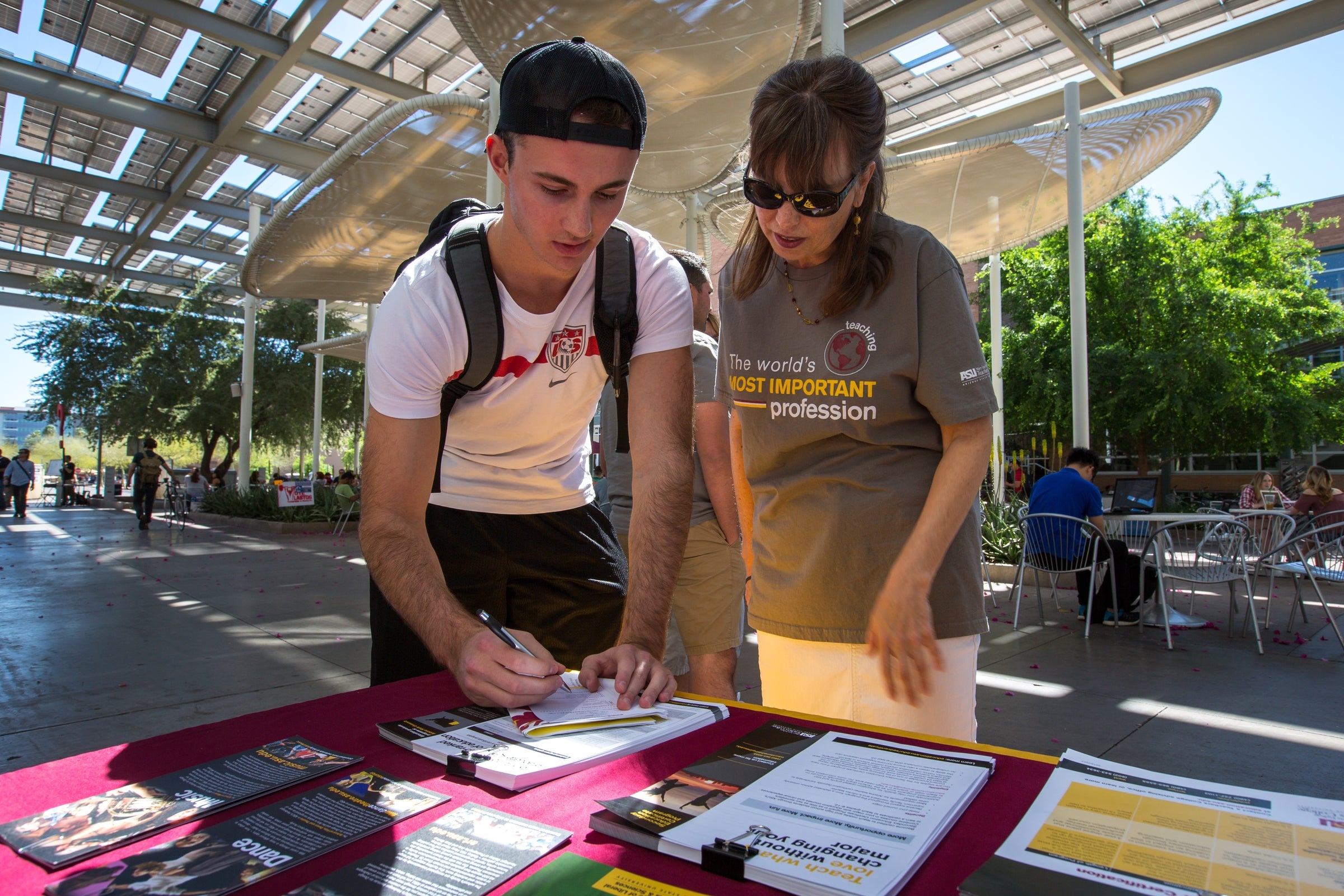 A student and an advisor talk at an education fair.