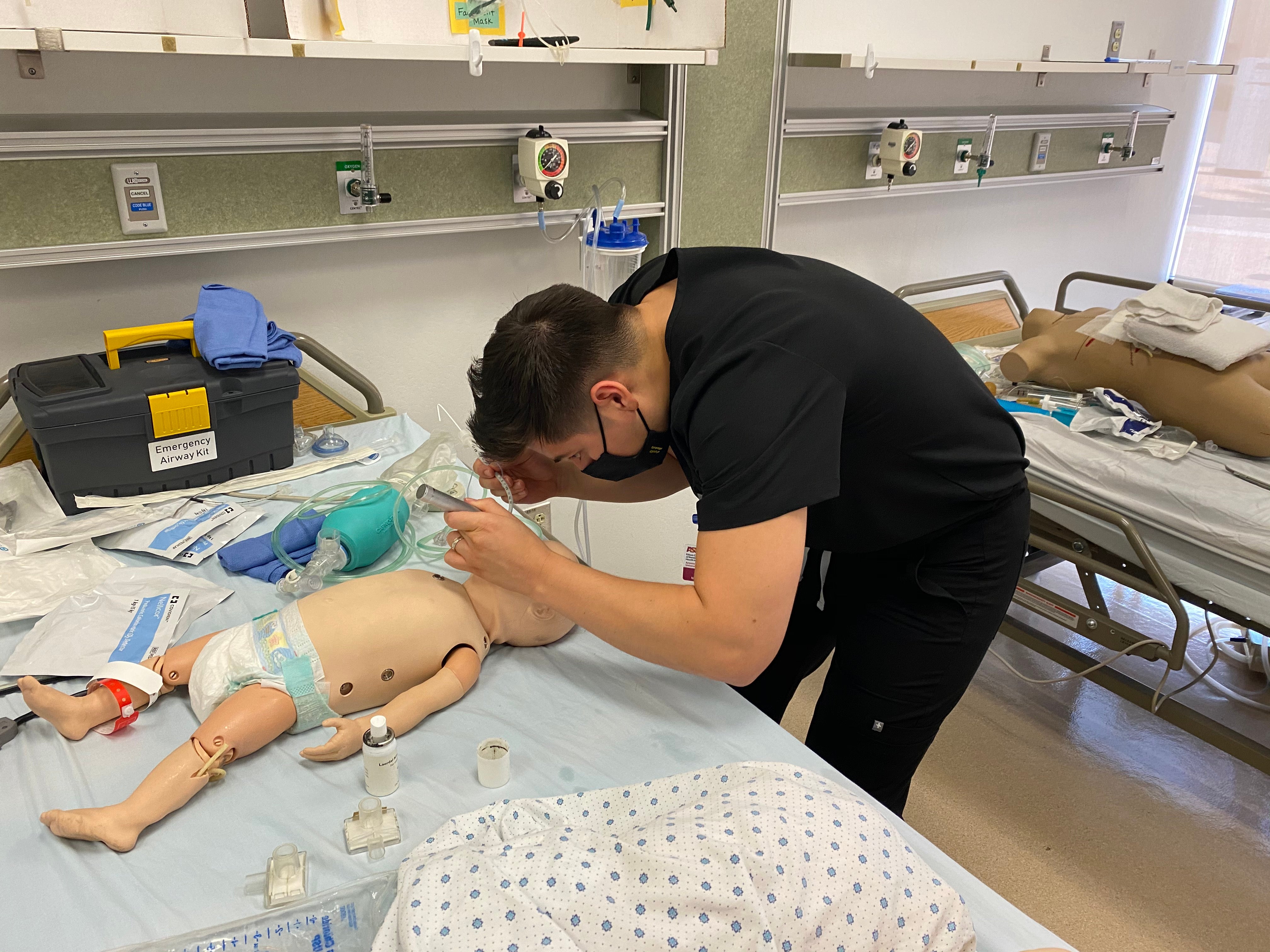 Reynaldo Kieser participates in an immersion experience, opening the airway of a pediatric patient