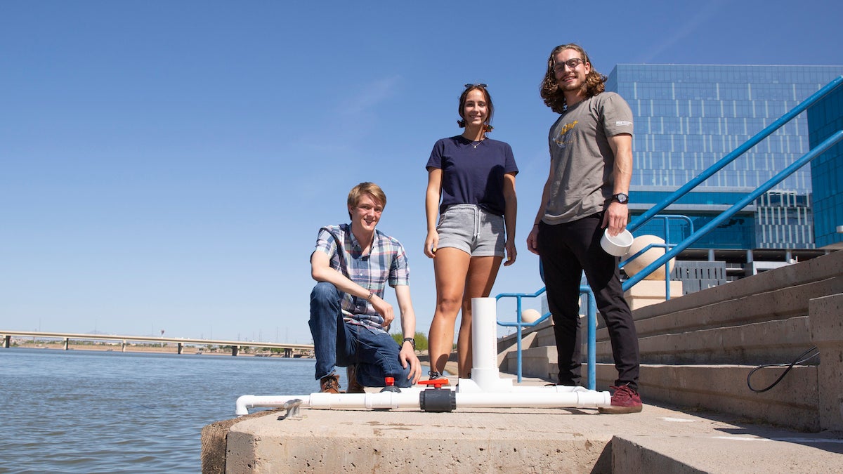 three people posing next to lakefront