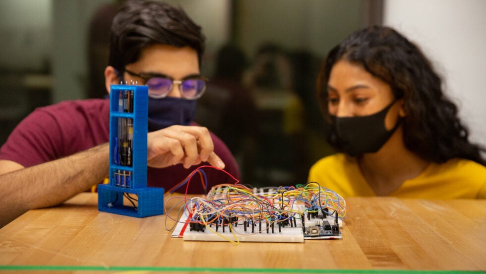 students working on electronic board