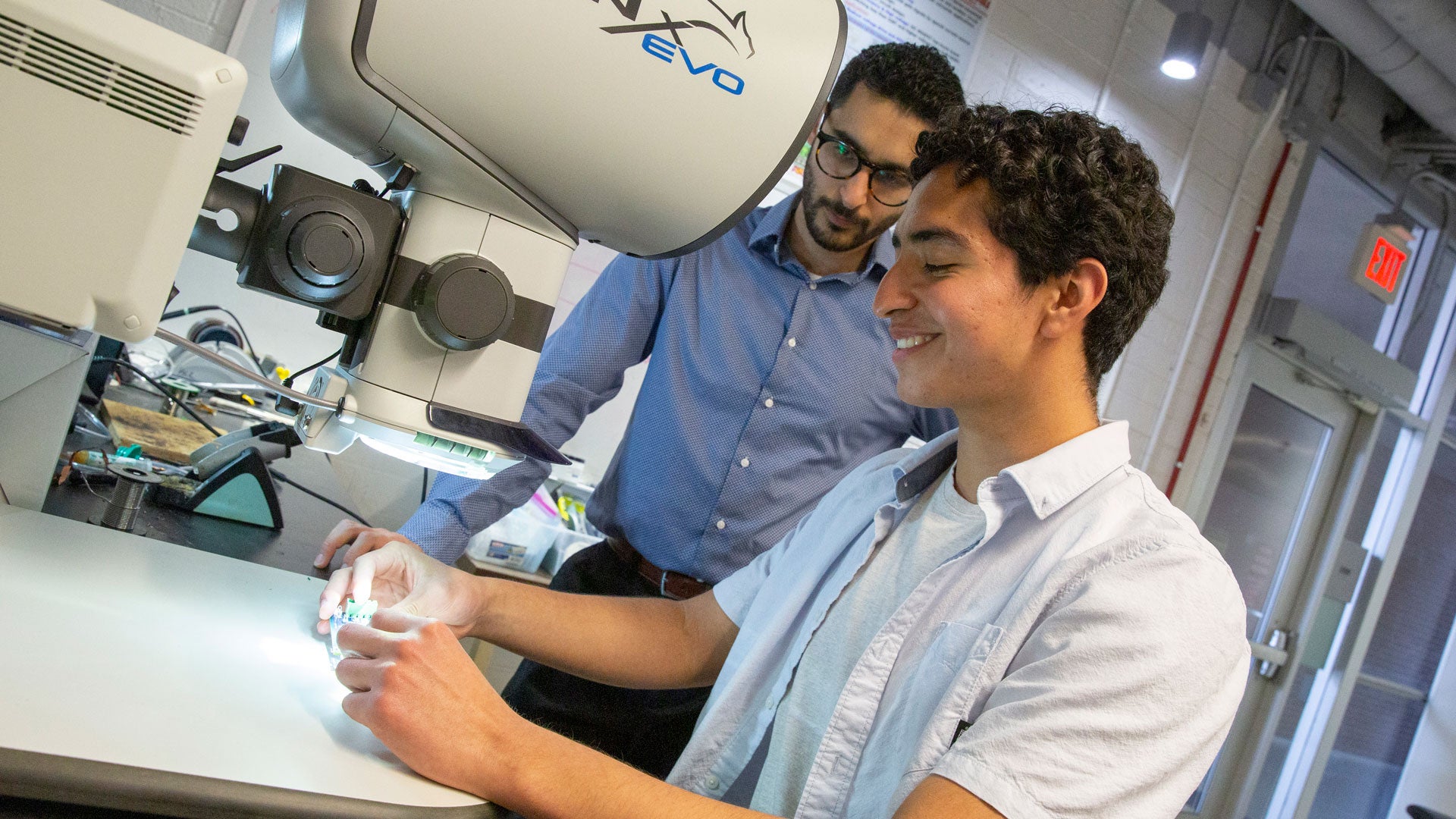 ASU electrical engineering junior Humberto Delgado (foreground) works with Mike Ranjram (background), an assistant professor of electrical engineering, on a FURI project.