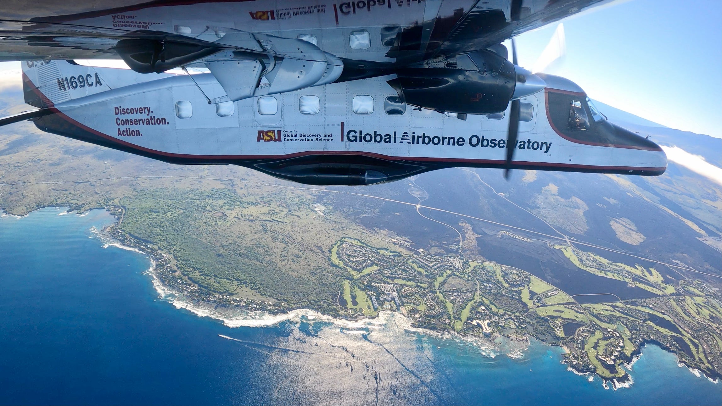 Plane flying over a coastline.