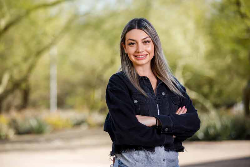 Ana Steletovic stands in front of a desert landscape