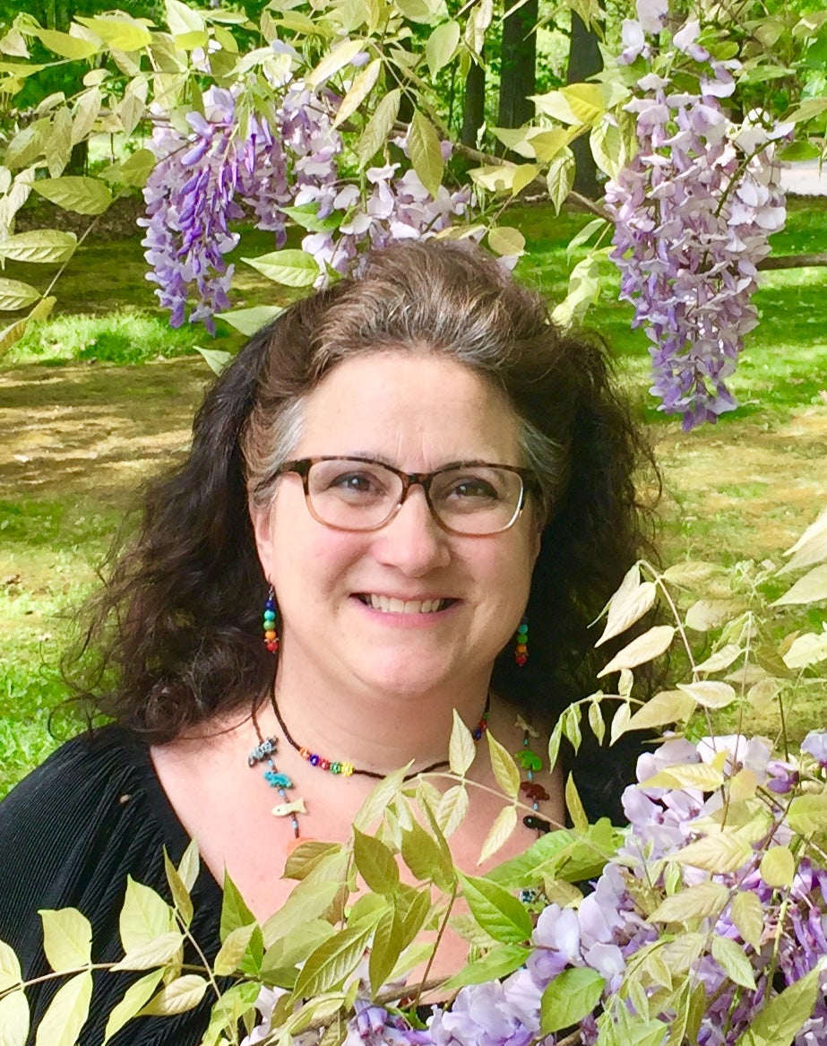 Woman poses under flowers