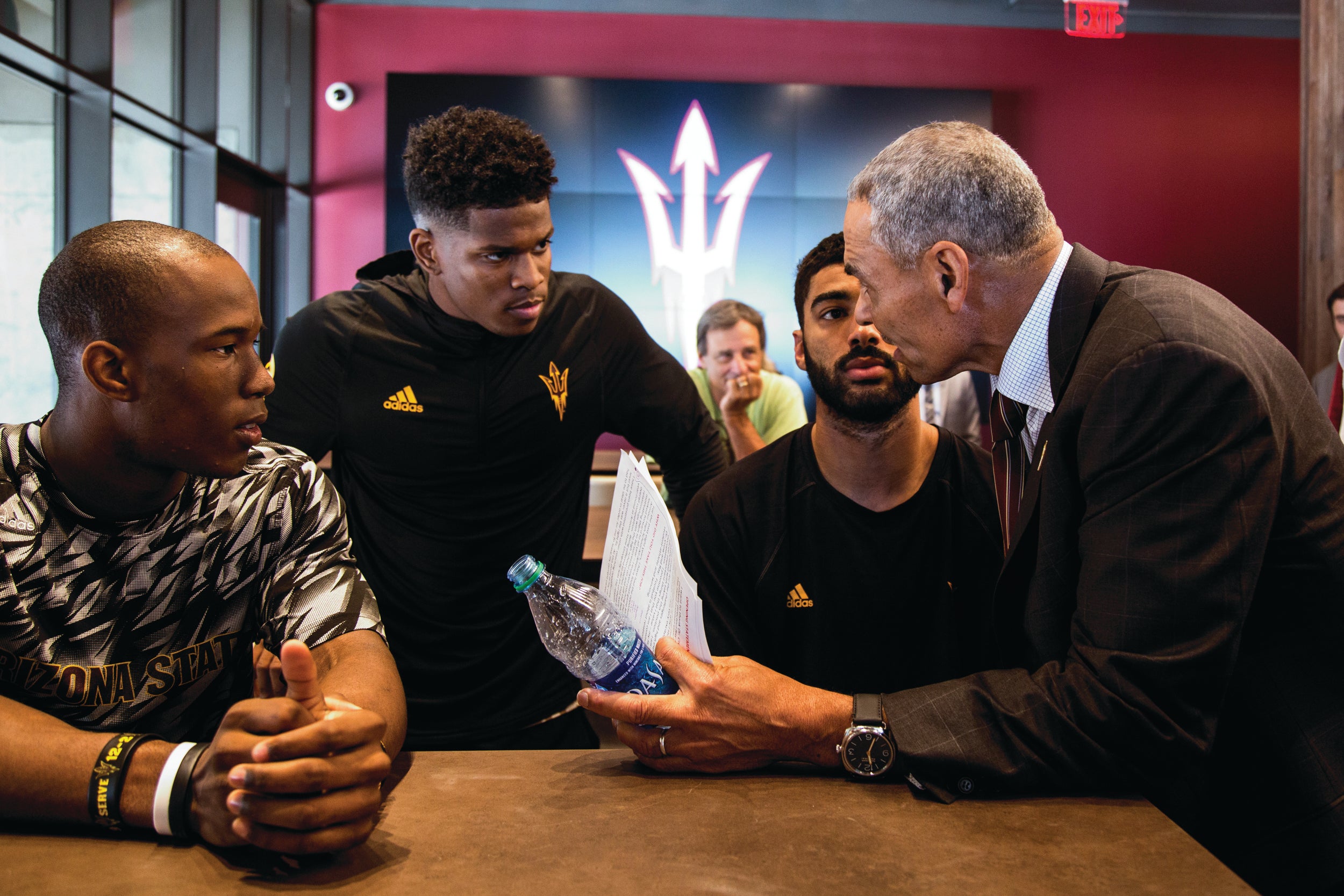 ASU Coach Herm Edwards talks with football players