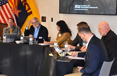 People on a panel sit at tables