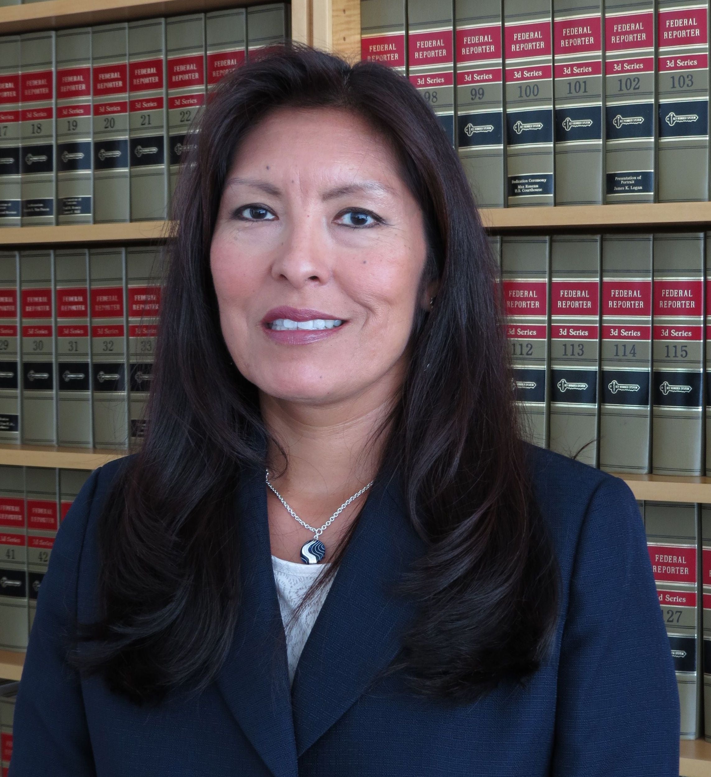 Native American woman with law books in the background