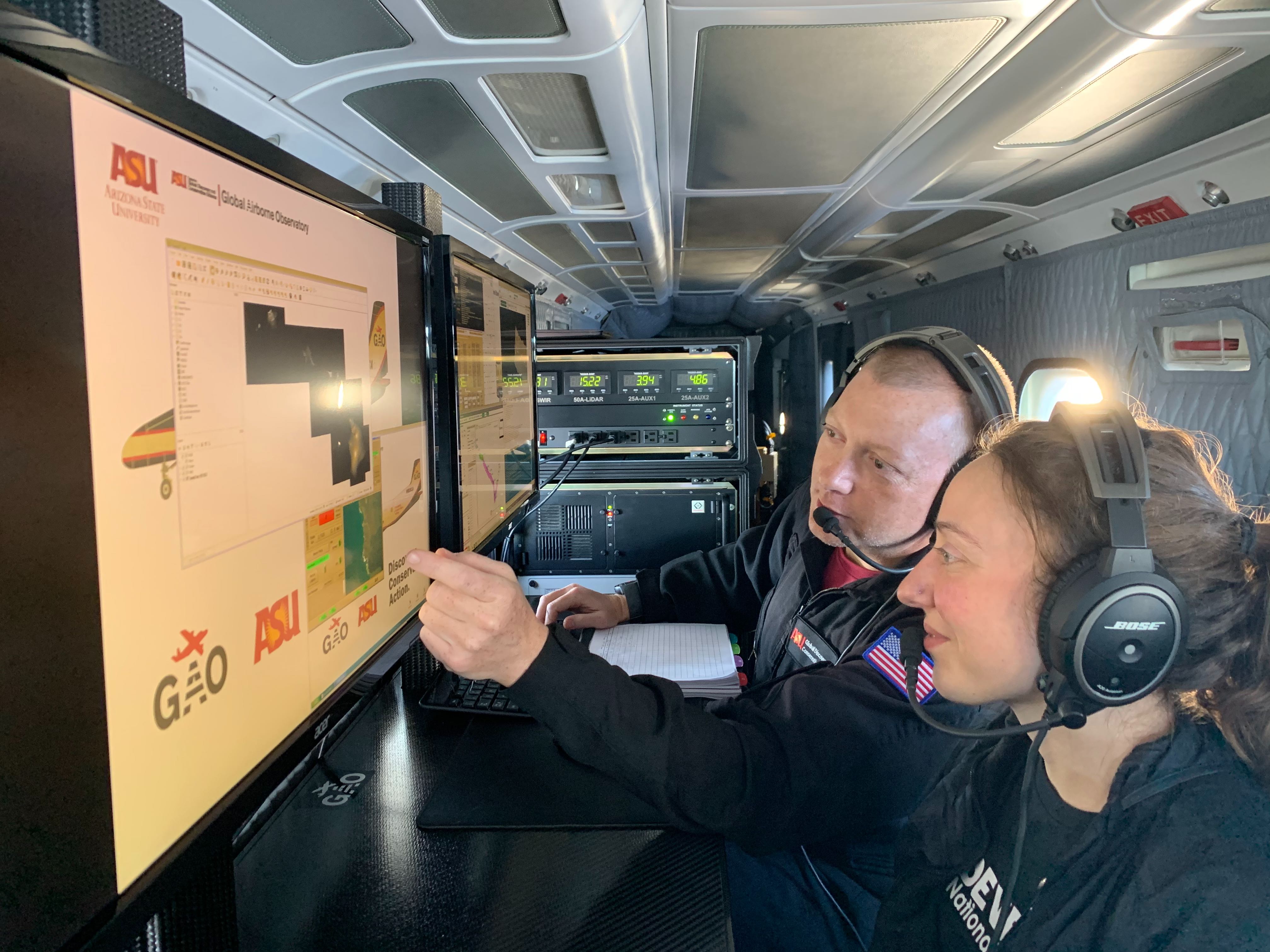 A researcher shows a student how to map coral reefs from an airplane