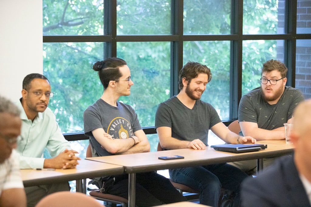 Four students sitting at table in classroom