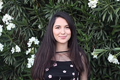 woman standing in front of bush with white flowers