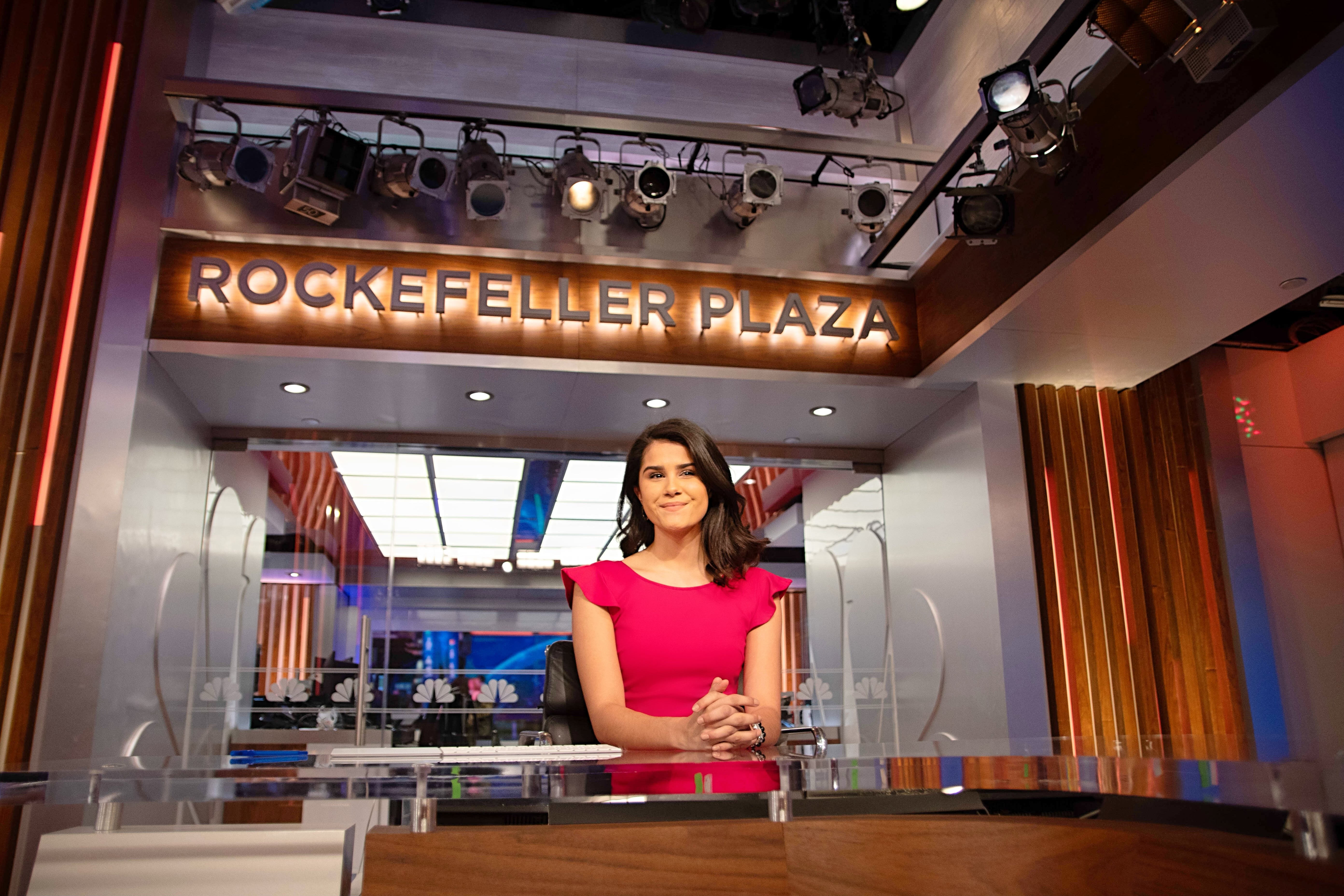 Woman in red dress sitting behind desk