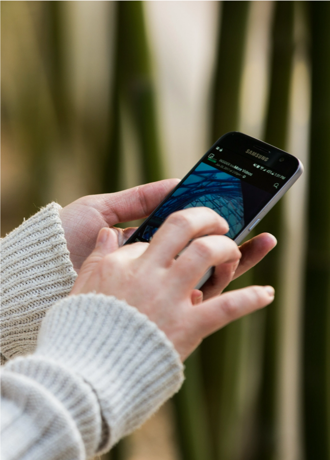 A pair of hands scrolling a mobile phone.